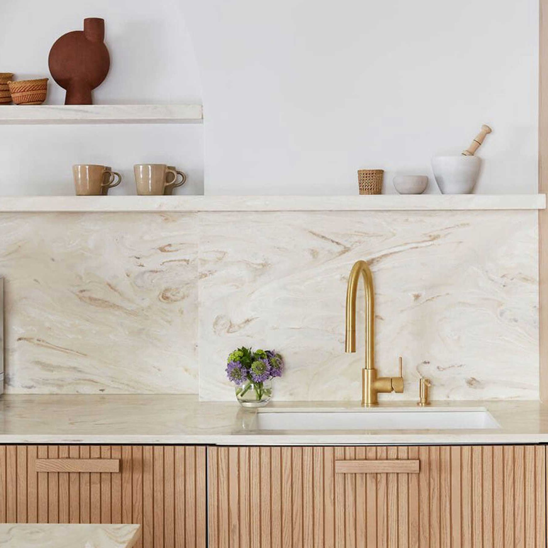 Corian worktop and matching splashback above fluted oak cabinetry