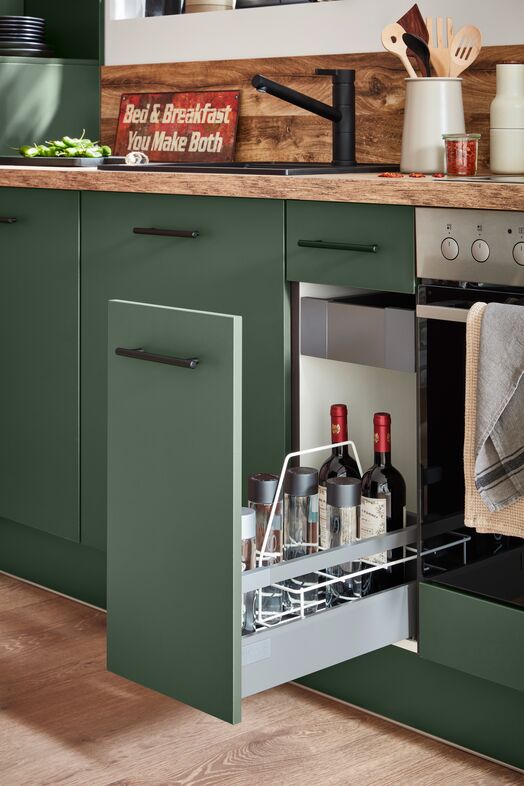 Impuls IP 1200 green base unit with a pull-out bottle store beside a built-in oven