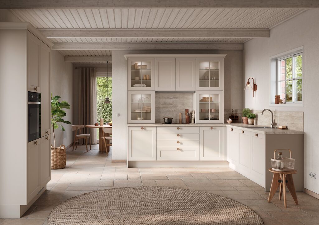 Pale Shaker kitchen with framed doors, glazed cabinets and a stone worktop